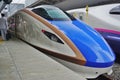 A blue and white E7 Series Shinkansen high-speed bullet train
