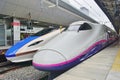 A blue and white E7 Series Shinkansen high-speed bullet train