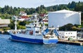 A blue and white fish trawler moored at a gas station in the harbour. Royalty Free Stock Photo
