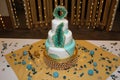 A blue and white geode wedding cake surrounded by blue flower-shaped candles and flower petals