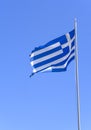 A blue and white Greek flag flies against a blue sky Royalty Free Stock Photo