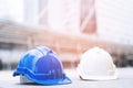 Blue and white hard safety wear helmet hat in the project at construction site building on concrete floor on city. helmet for work Royalty Free Stock Photo