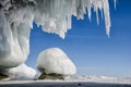 Blue white ice cave with icicle stalactites, blue sky and stone covered ice Royalty Free Stock Photo