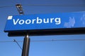 Blue and white name sign Voorburg on the platform of the railway station in the Netherlands.