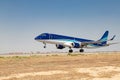 Blue with white passenger Embraer 190 takes off from the runway at the airport.