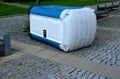 blue white plastic mobile toilet lying on its side