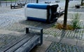blue white plastic mobile toilet lying on its side