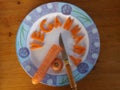 A blue and white plate of carrot spelling veganuary