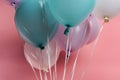 Blue, white and purple decorative festive balloons on pink background. Royalty Free Stock Photo