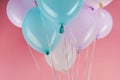 Blue, white and purple festive balloons on pink background. Royalty Free Stock Photo