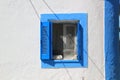 Blue and white shuttered window in wall on Greek Island