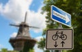 The traffic sign of a one way street on a street in front of a windmill. Royalty Free Stock Photo