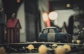 Blue and white small car toy model on the road. Mini car toy in the city near building on blurred background with bokeh. Cartoon Royalty Free Stock Photo