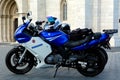 Blue and white sport and touring bikes in bright summer light in front of stone church facade