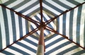 Blue and white striped beach umbrella in sunlight Royalty Free Stock Photo