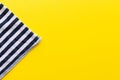 Blue and white striped fabric closeup triangle on a bright yellow background. Top view with copy space. Summer concept template Royalty Free Stock Photo