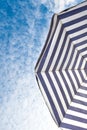 Blue and white sun beach umbrella and blue sky with clouds Royalty Free Stock Photo