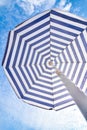 Blue and white sun beach umbrella and blue sky with clouds Royalty Free Stock Photo