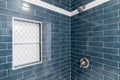 A blue and white tiled shower.