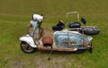 Blue and White very rusty Lambretta Motor Scooter with rusty helmet and gloves.