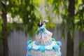 Blue and white wedding cake with wedding couple statue and blurred background at an outdoor wedding concept Royalty Free Stock Photo