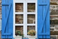 Blue and white wooden window frames of an old stone house Royalty Free Stock Photo