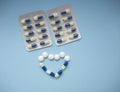 Blue and white with yellow medical pills and tablets in heart shape on a blue background with copy space Royalty Free Stock Photo