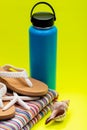 Blue Wide Mouth Insulated Stainless Steel Bottle, Women`s Causal Flip Flops, Beach Towel, Starfish and Seashell on yellow Royalty Free Stock Photo