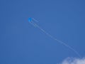 Blue wind kite in a blue sky with white clouds Royalty Free Stock Photo