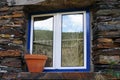 Blue window with blue trim and a rustic stone wall Royalty Free Stock Photo