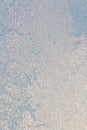 Blue window glass covered hoarfrost ice pattern texture with water drops. Cold nature winter background