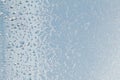 Blue window glass covered hoarfrost ice pattern texture with water drops. Cold nature winter background Royalty Free Stock Photo