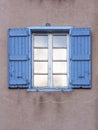 A blue window with open wooden shutters
