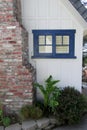 Blue window, white wall and brick chimney. Royalty Free Stock Photo