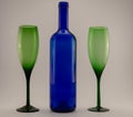 Blue wine bottle and two green glasses Royalty Free Stock Photo
