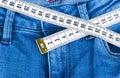 A blue woman jeans and ruler, concept of diet and weight loss. Jeans with measuring tape. Healthy lifestyle, dieting, fitness. Royalty Free Stock Photo