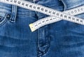 A blue woman jeans and ruler, concept of diet and weight loss. Jeans with measuring tape. Healthy lifestyle, dieting, fitness. Royalty Free Stock Photo