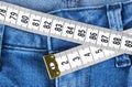 A blue woman jeans and ruler, concept of diet and weight loss. Jeans with measuring tape. Healthy lifestyle, dieting, fitness. Royalty Free Stock Photo