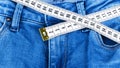 A blue woman jeans and ruler, concept of diet and weight loss. Jeans with measuring tape. Healthy lifestyle, dieting, fitness. Royalty Free Stock Photo