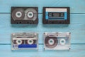 On a blue wooden background, there are four audio cassettes