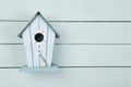 Blue wooden bird house with a metal key on a blue wooden background with copy space as a concept for a new home Royalty Free Stock Photo