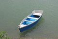 Blue wooden boat is chained to the dock