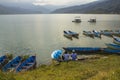 Blue wooden boats and catamarans on the water. rowing boats on the lake against the backdrop of green mountains. guys under an Royalty Free Stock Photo