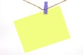 Blue wooden clip clamped the yellow note. Royalty Free Stock Photo