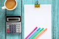 Blue wooden desk table with paper ream, color pen, calculator an