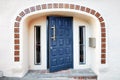 Blue wooden door, decorative tiles, windows and beige walls of the entrance of a vintage building Royalty Free Stock Photo