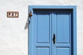 Blue wooden door with old bell and house number sign Royalty Free Stock Photo