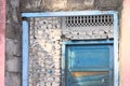 Blue wooden door in a stone wall of an abandoned pink house Royalty Free Stock Photo