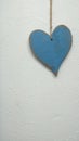 Blue heart hanging on white background