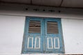 A blue wooden house window, ancient style, with white walls